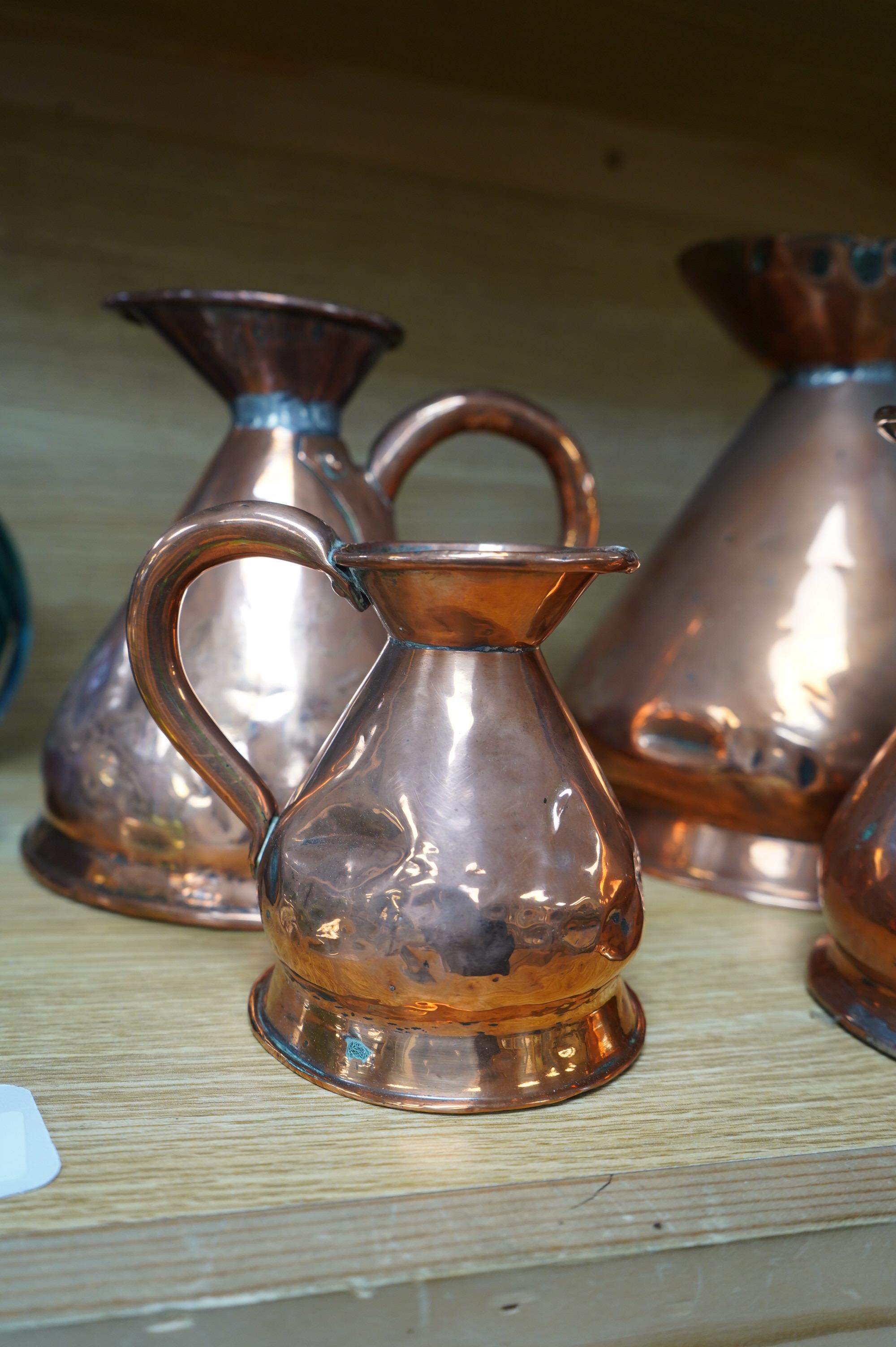 A graduated set of four Victorian copper measures, tallest 22cm. Condition - fair